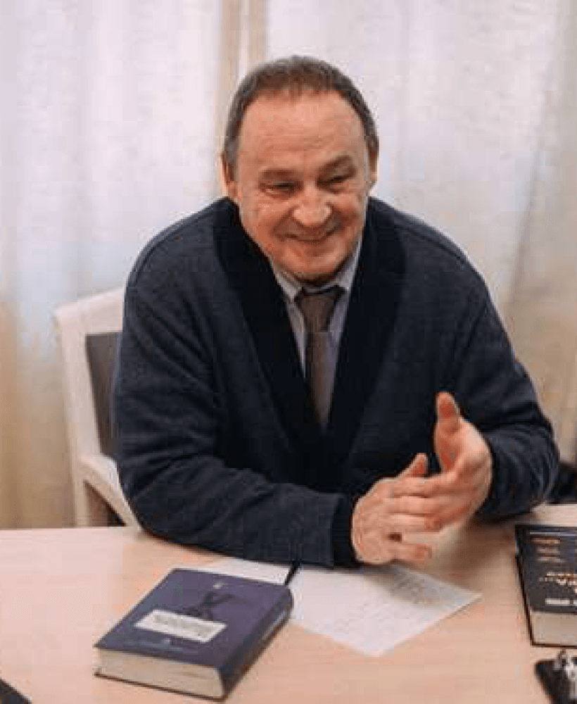 Адвокат Андрей Баганов за рабочим столом с книгами